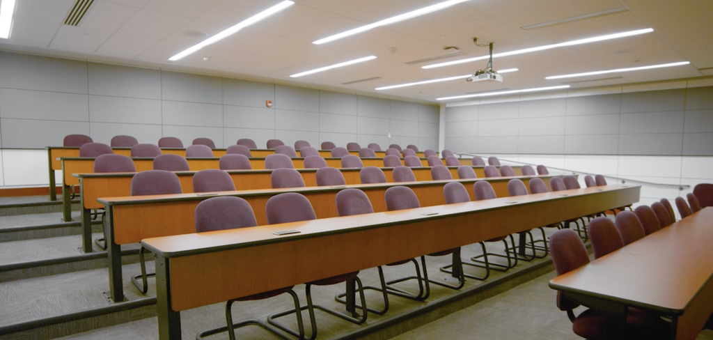 Main Lecture Hall on the lower level, from the front of the room facing the desks and back of the room.