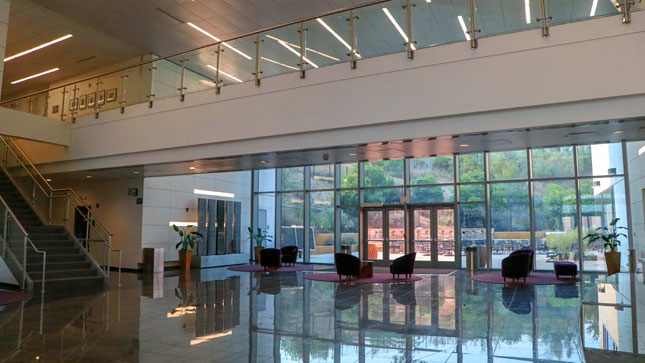 Interior lobby of the University Center facing west towards the exterior patio with lots of windows.
